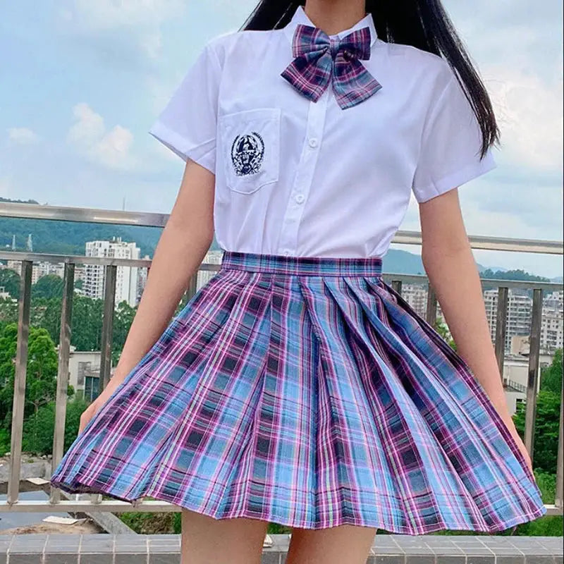ZOKI plaid pleated mini skirt in pink and blue with high-waist fit, shown with a white shirt