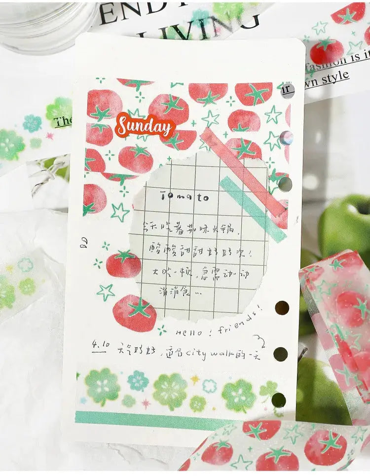 Decorative adhesive washi tape with red tomato pattern and green leaves on white background