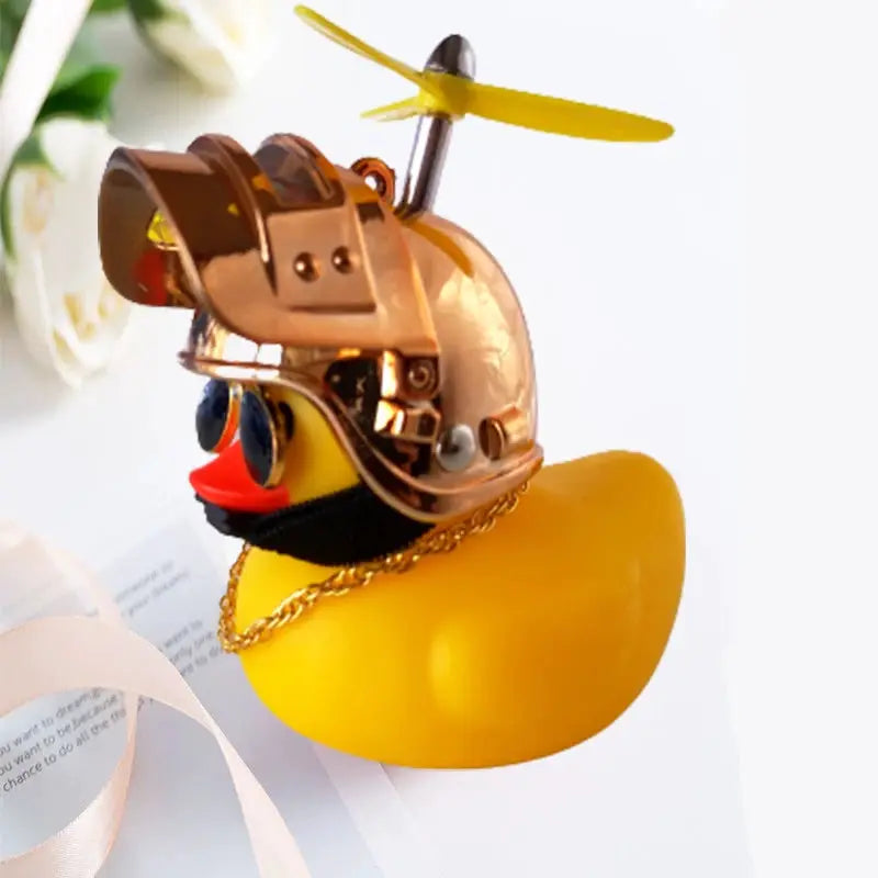 Yellow rubber duck car interior decoration wearing a metallic gold helmet with propeller and blue sunglasses