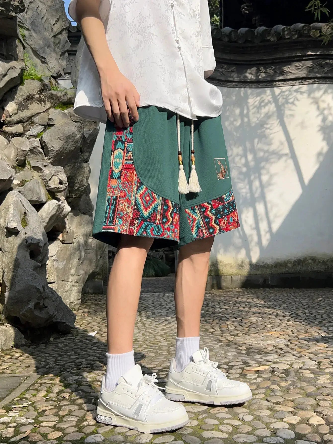 Men's green shorts with colorful embroidery panels, pockets and tassel drawstring