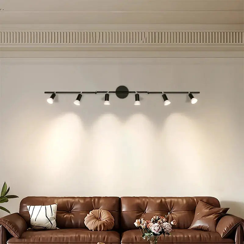 GU10 LED ceiling light bar with five adjustable black spotlights over a brown leather sofa
