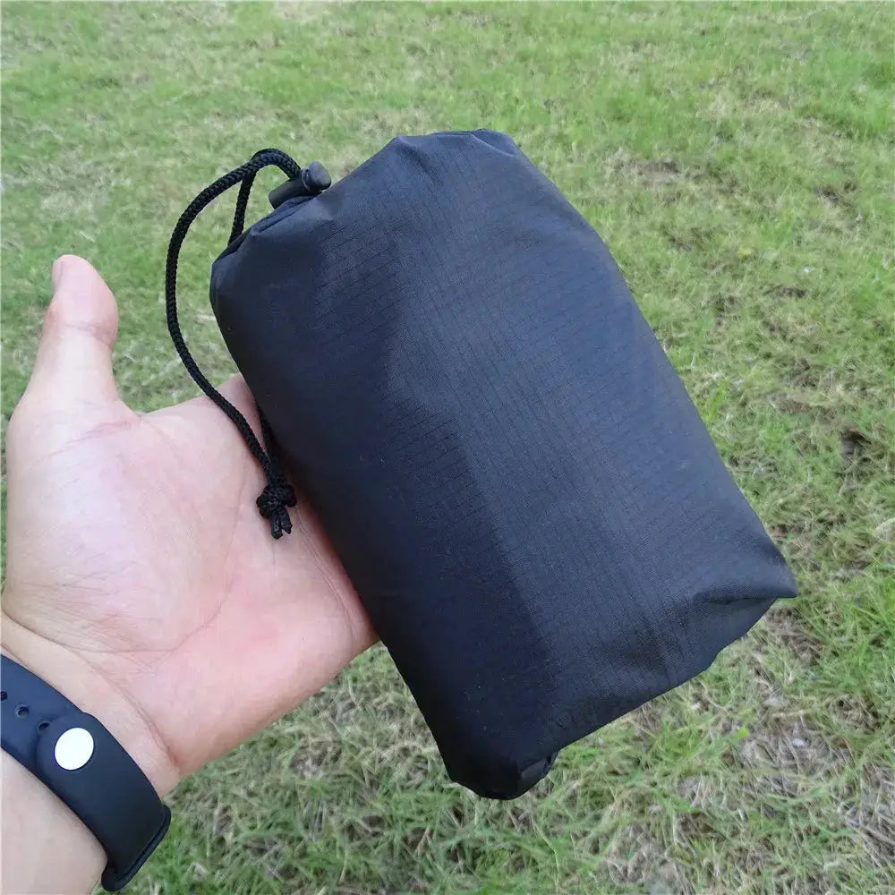 Waterproof camping mat, ultralight black, rolled compact with drawstring pouch for easy portability.