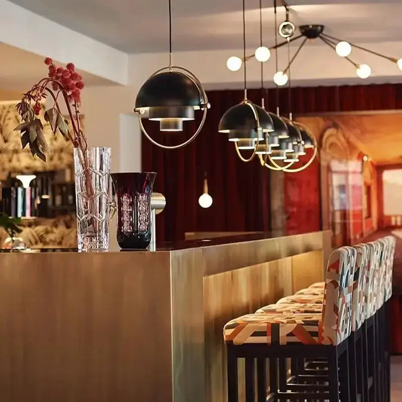 Pendant lights: five black dome fixtures with gold rings hanging above a kitchen island.