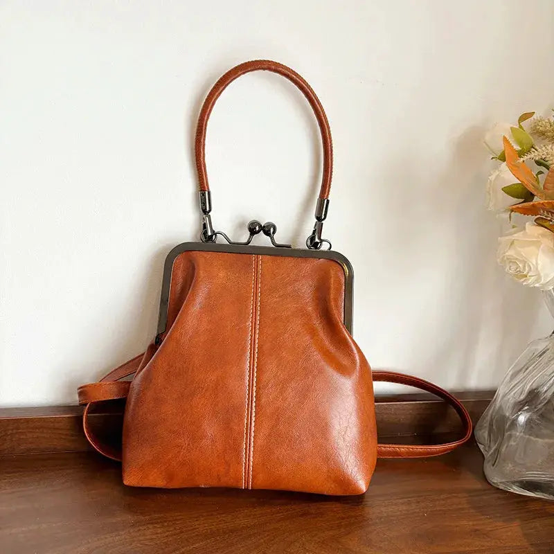 Vintage-style brown PU leather handbag with metal frame clasp, top handle and shoulder strap