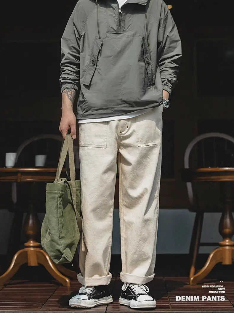 Maden vintage beige men's denim pants, loose-fit straight trousers, shown with gray pullover and olive tote