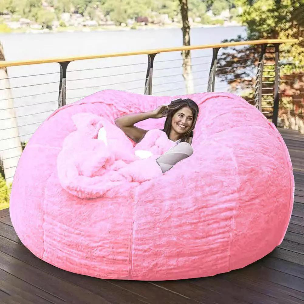 Simples Market pink giant bean bag sofa bed lounge on an outdoor deck with a smiling person inside