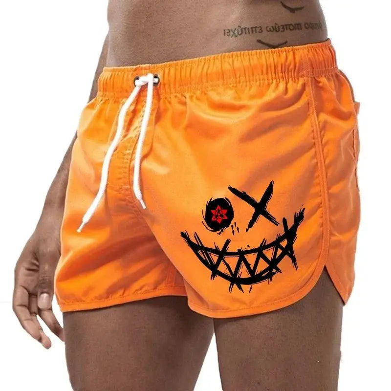 Men's orange board shorts with white drawstring and front graphic.