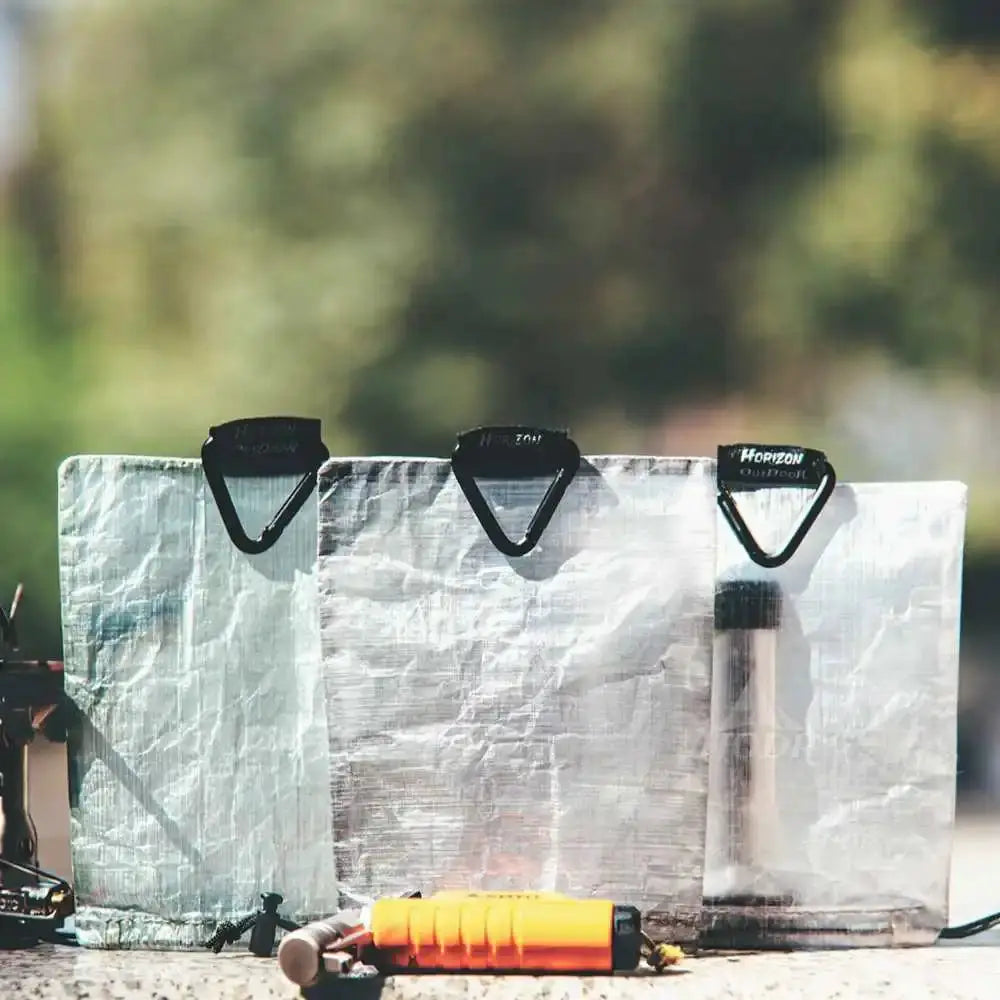 STASHLITE Dyneema DCF stuff sacks, three translucent sacks with black carabiner handles.