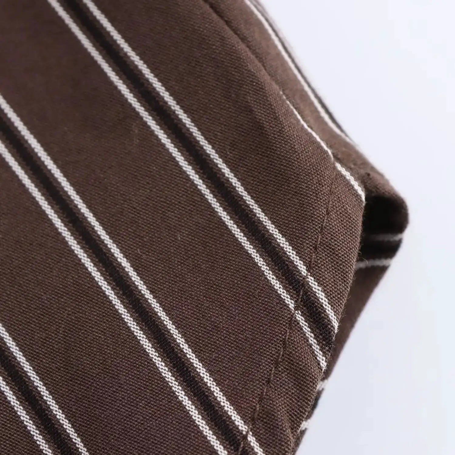 Women's brown striped blouse fabric close-up; long-sleeve shirt with white stripes