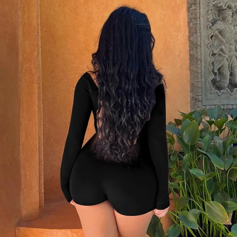 Hugcitar backless long-sleeve playsuit in black with lace-up detail; slim-fit romper by Simples Market