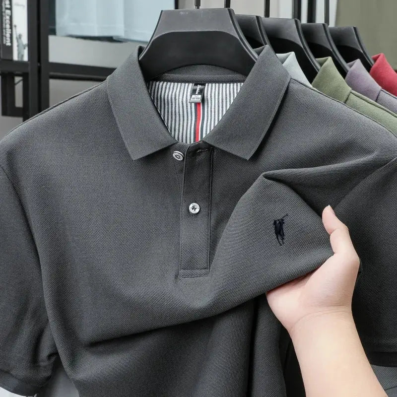 Dark gray 100% cotton polo shirt with pony embroidery on chest; six polo shirts on hangers.