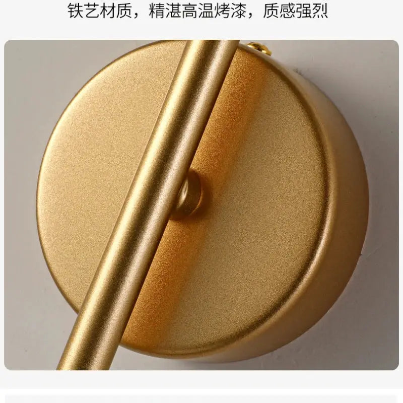 Gold LED wall lamp with round backplate and slim vertical arm, modern bedside sconce