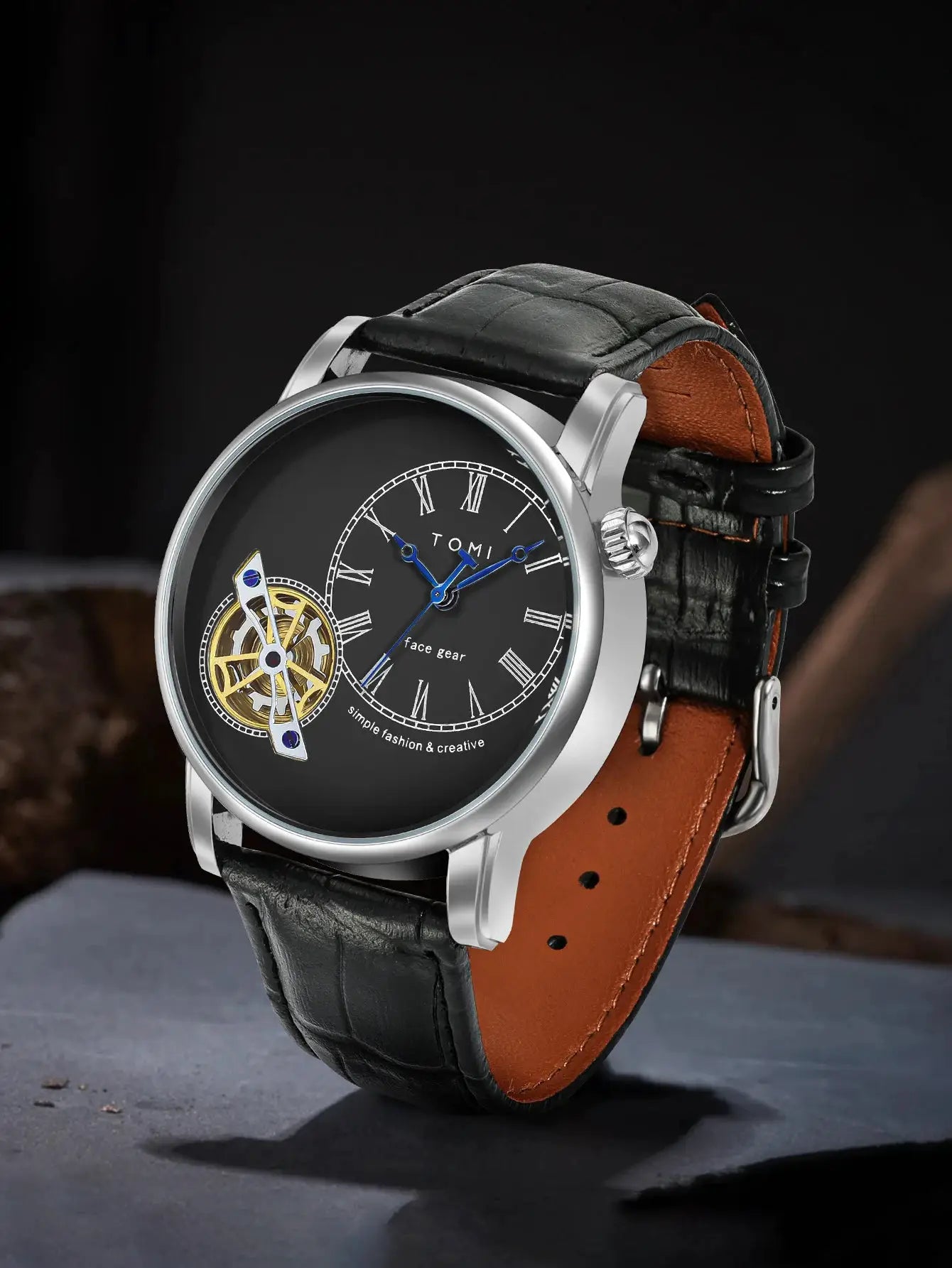 TOMI men's quartz watch with black dial, blue hands, skeleton gear, silver case, black leather strap with tan lining