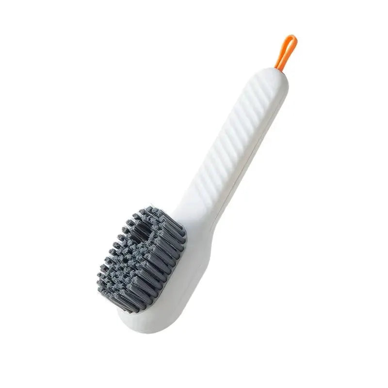 Shoe brush by Simples Market, white handle with grey bristles and orange hanging loop