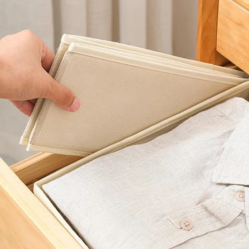 Foldable drawer organizers in beige fabric; two units in a wardrobe drawer with a shirt.