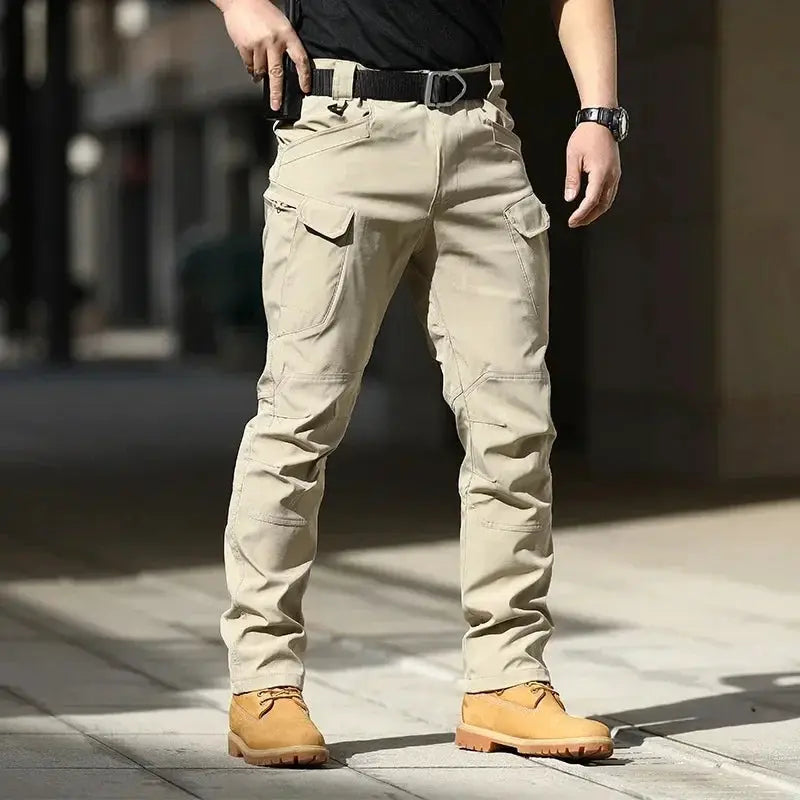 Mens beige waterproof cargo pants with multiple pockets and knee seam details