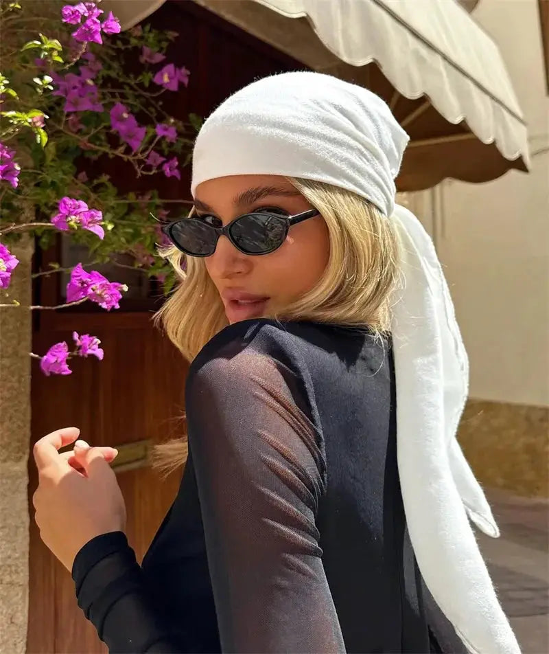 Mozision jumpsuit black sheer long-sleeve see-through, model with white headscarf and sunglasses.