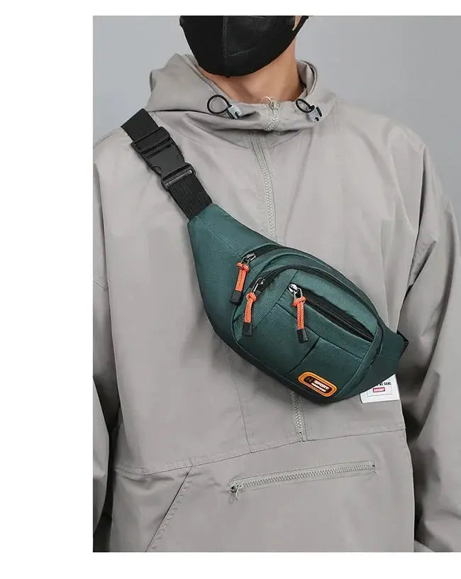 Oxford waterproof waist bag in green with orange zipper pulls worn as a crossbody fanny pack.