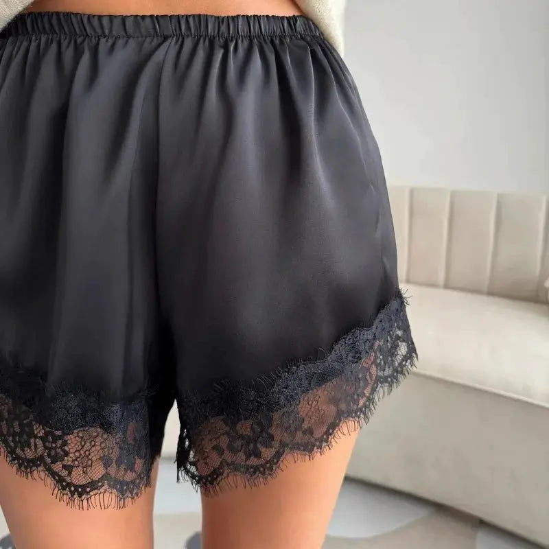 Women's black satin shorts with lace trim at the hem and elastic waistband
