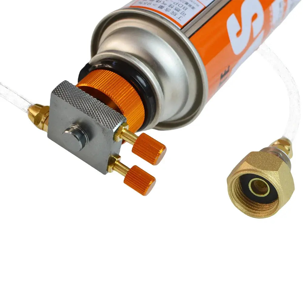 Camping gas stove refill adapter with brass fittings and orange knurled knobs attached to a gas canister.