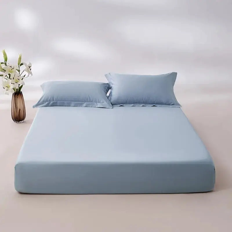 Egyptian cotton fitted sheet in light blue on bed with matching pillows