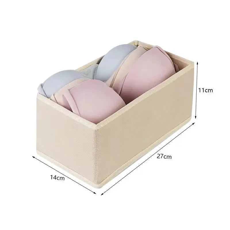 Foldable fabric drawer organizer in beige holding four folded garments; wardrobe storage box 27x14x11 cm.