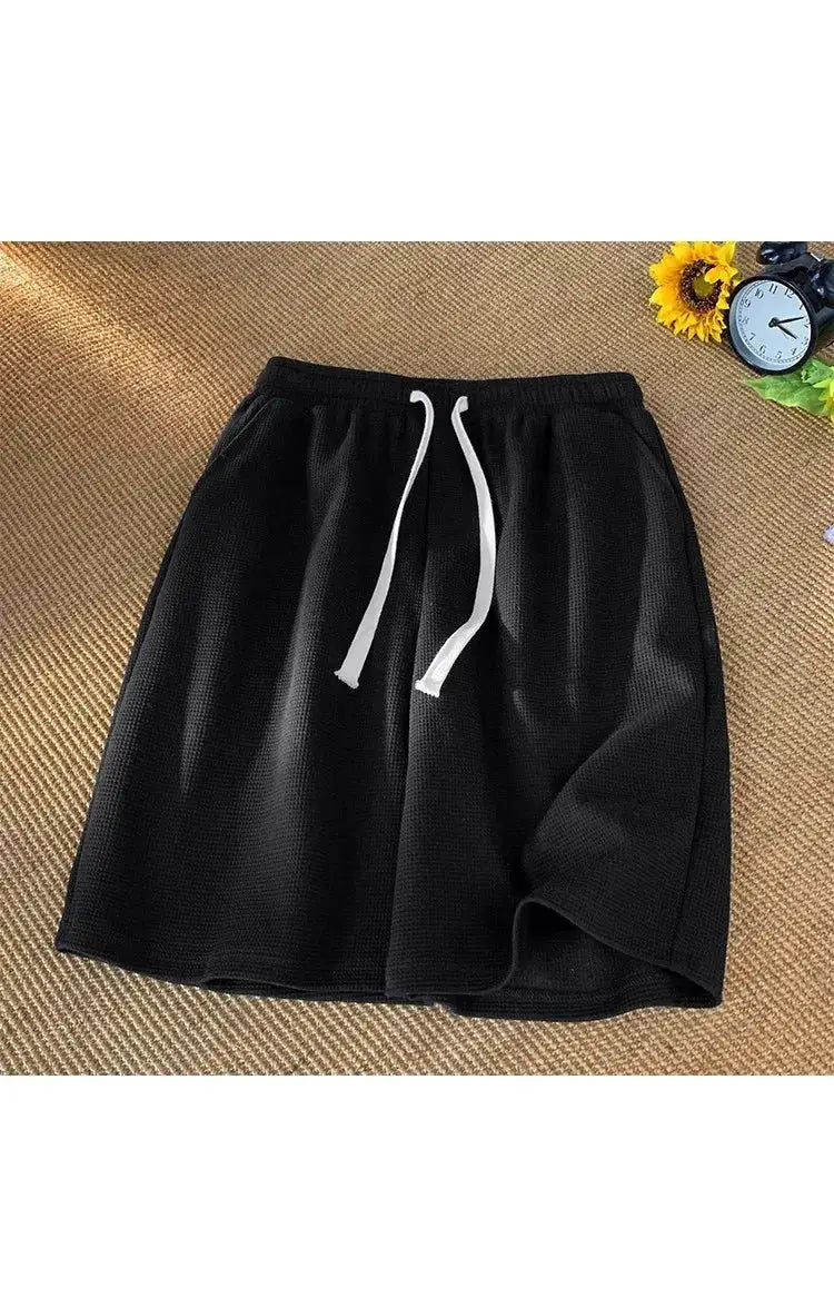 Men's black waffle shorts with white drawstrings; loose casual summer sportswear.