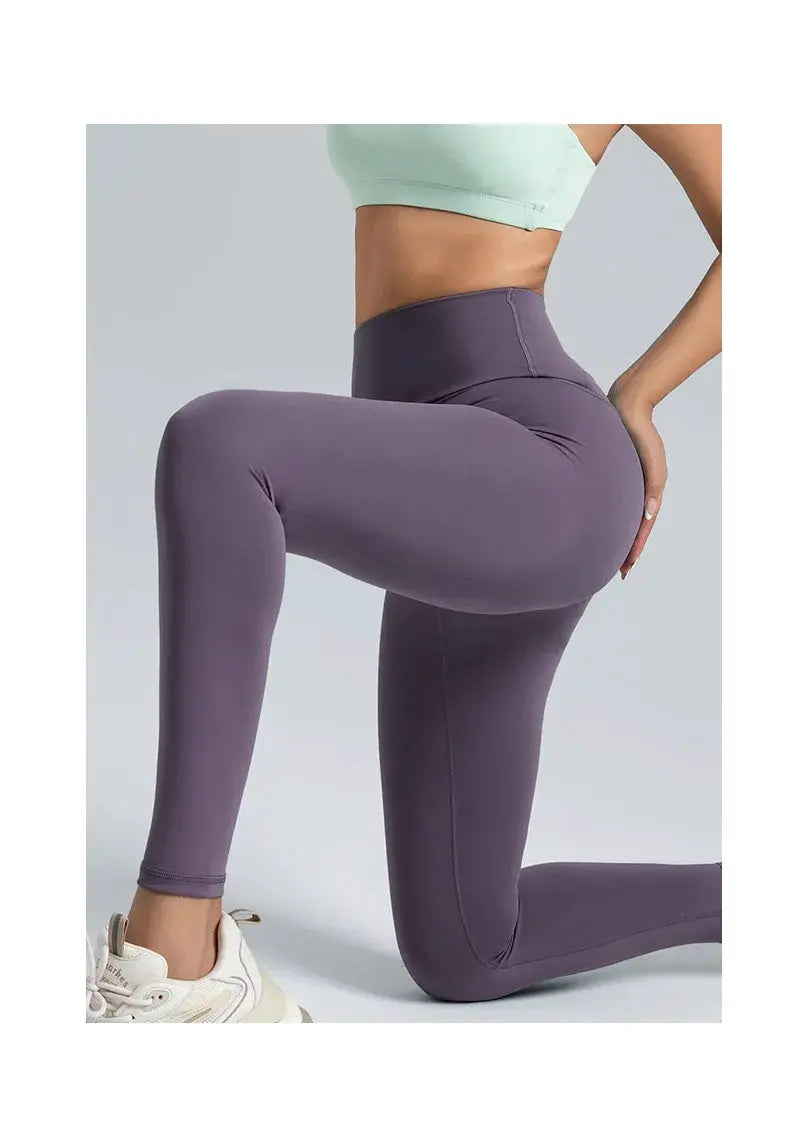 Purple high-waisted women's yoga leggings with a sleek, tight fit