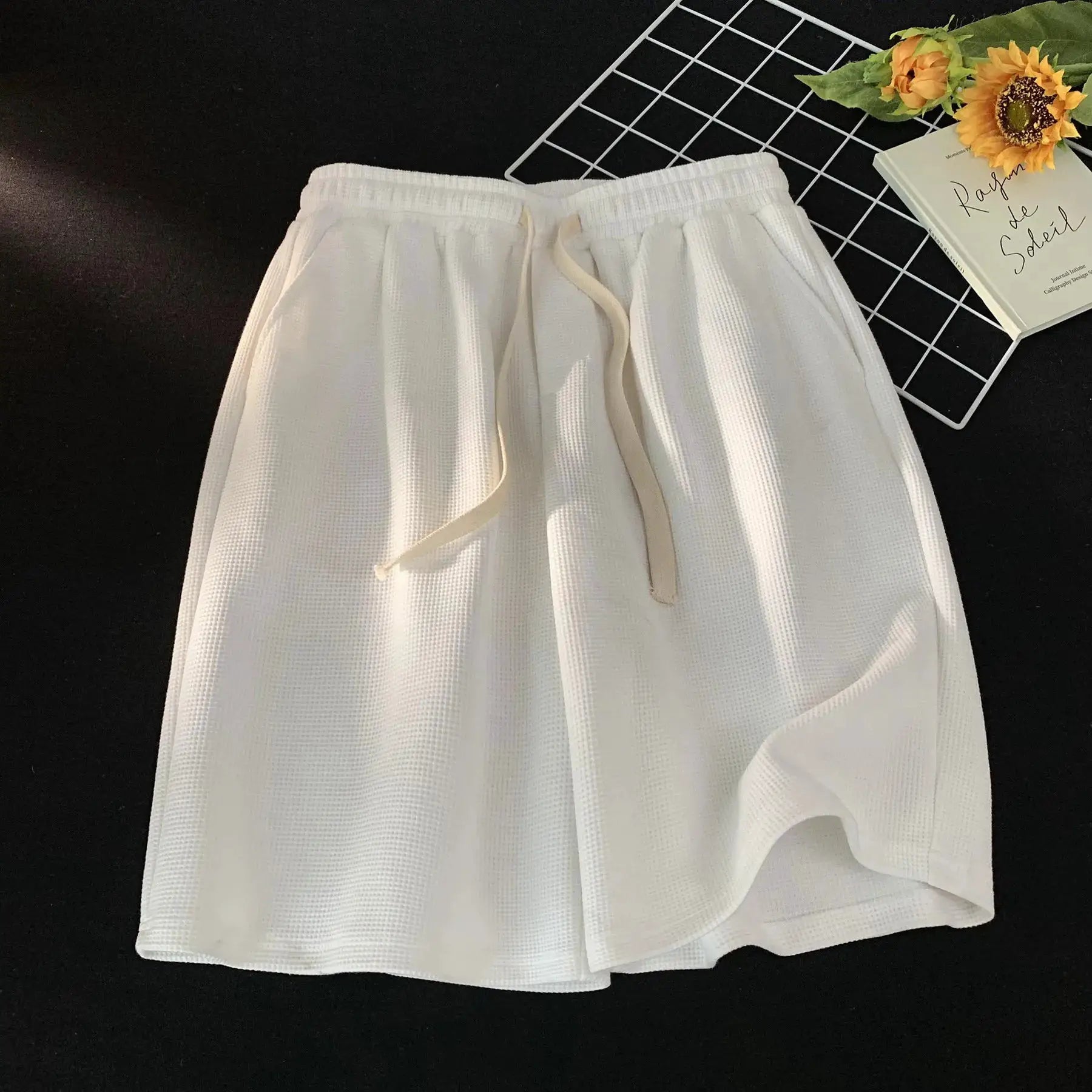White waffle-textured men's shorts with beige drawstring, loose casual summer fit