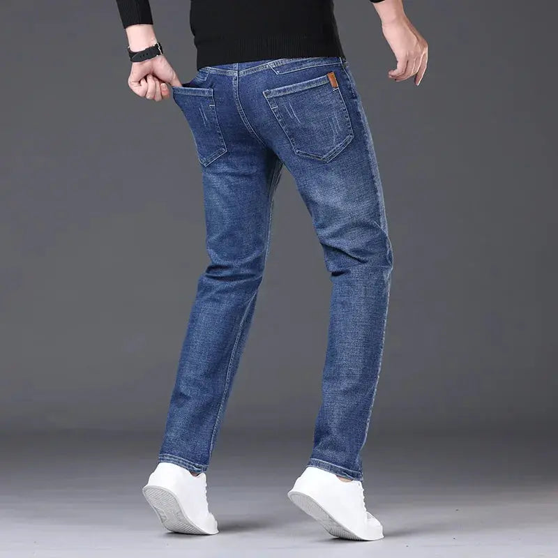 Men's straight jeans by Simples Market in blue denim with back pockets and orange tag.