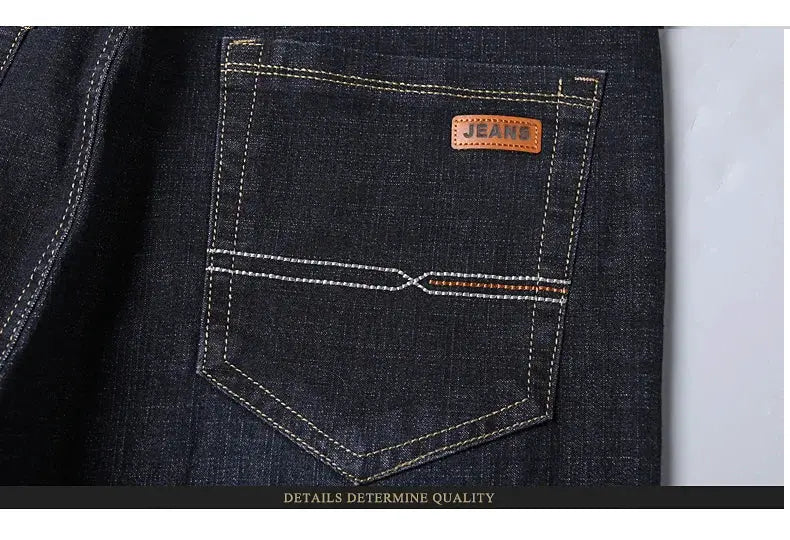Men's soft black denim jeans with brown leather back-pocket patch and contrast stitching.