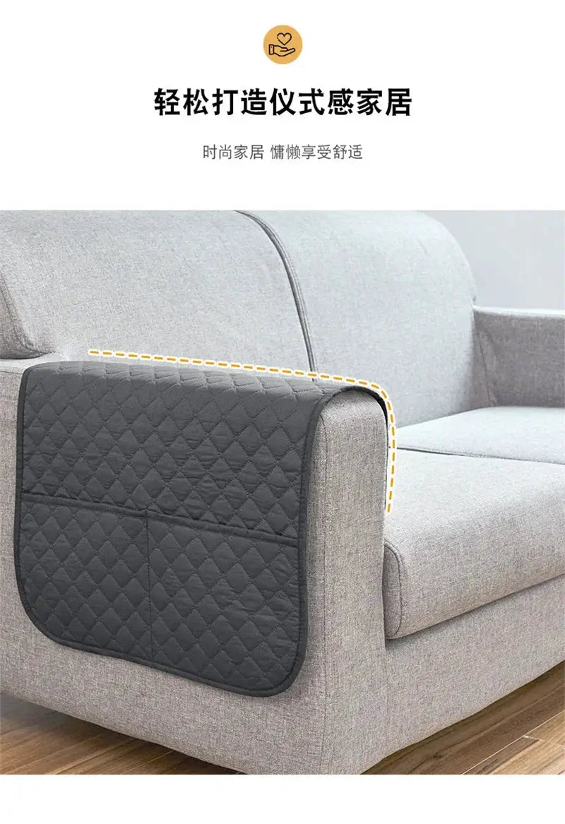 Sofa armrest cover with pockets in dark gray quilted fabric, a hanging storage bag for remote and cellphone.