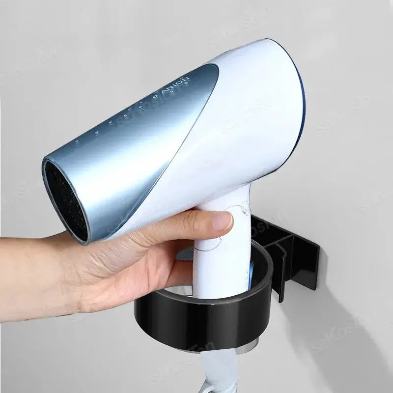 Wall-mounted hair dryer holder rack in black with adhesive mount, holding a silver hair dryer.