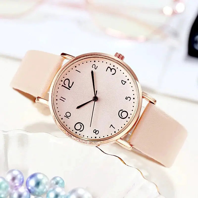 Women's pink leather strap analog quartz watch with a rose-gold-tone case and Arabic numerals