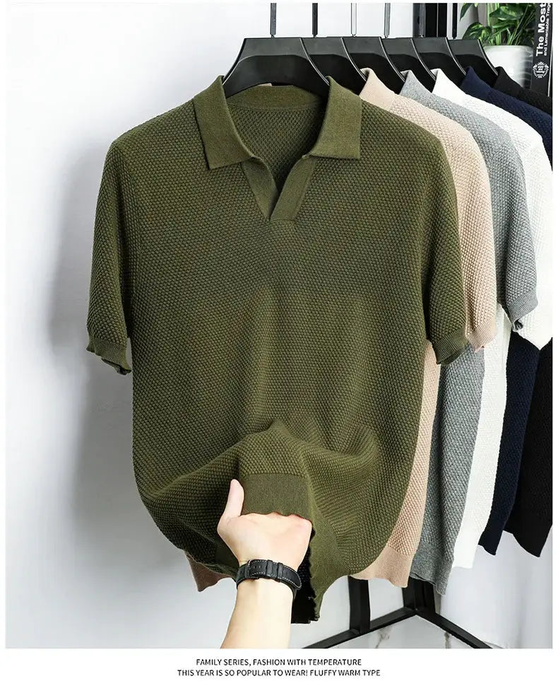 Olive green men's 100% cotton polo shirt, short-sleeve knit texture, on a hanger with other colors on the rack.