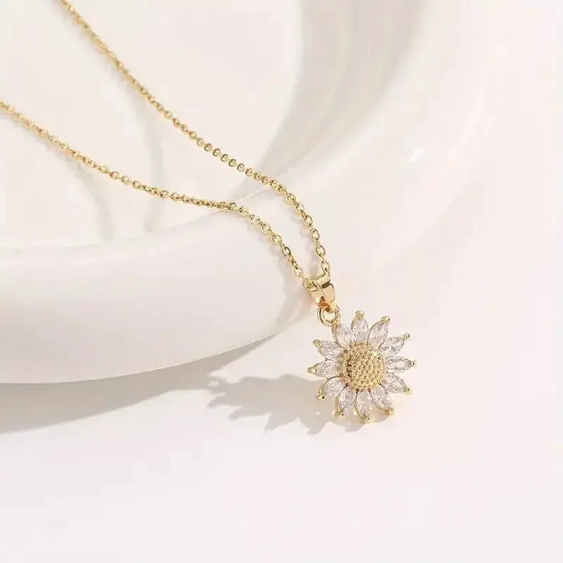 Gold-tone sunflower pendant necklace with crystal-accented petals on a delicate chain