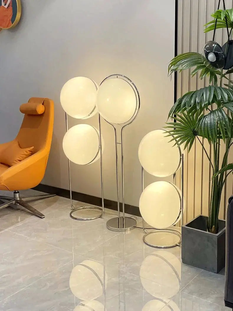 Floor lamp set: five modern white acrylic circular LED lamps with chrome stands for living room.