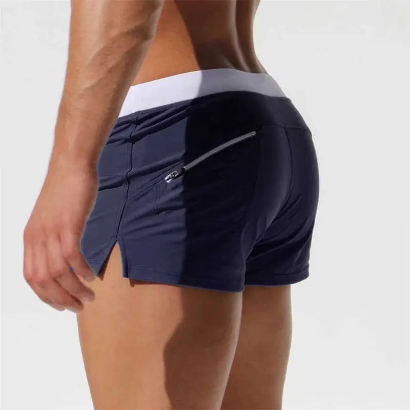 Men's navy blue swim trunks with white waistband and zippered back pocket