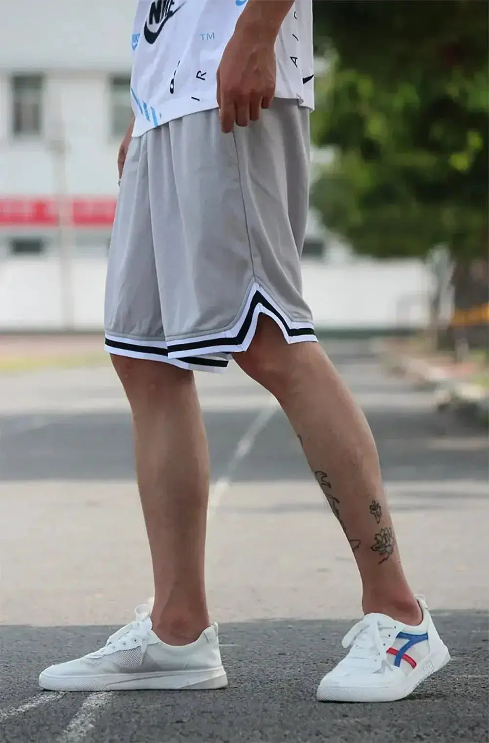 Men's gray mesh quick-dry basketball shorts with white trim, paired with white sneakers