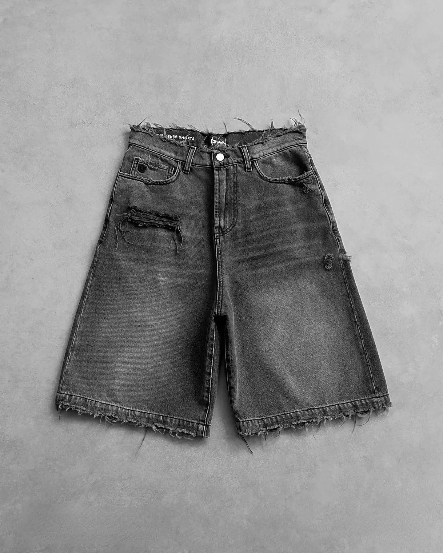 Distressed denim shorts for men with ripped holes and frayed hems, zipper fly
