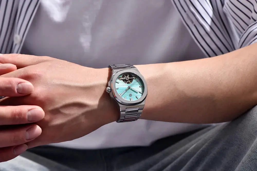 Pagani Design men's stainless steel skeleton watch with teal dial on a silver bracelet.