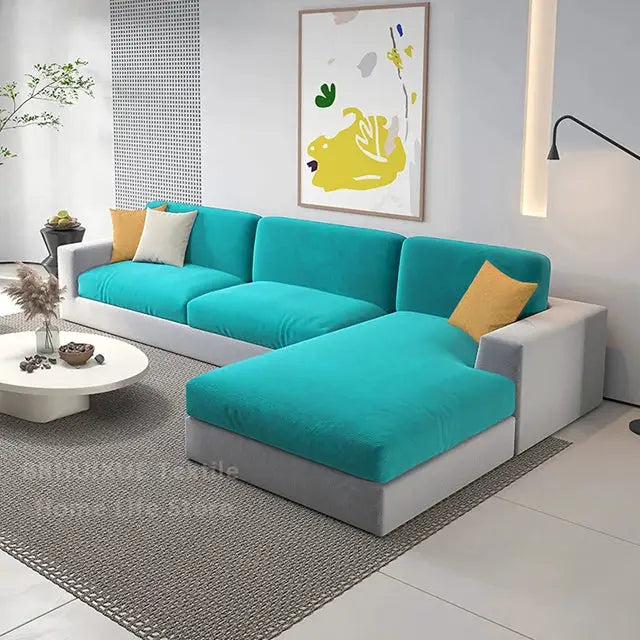 Velvet teal sofa cushions on an L-shaped sectional with gray base in a modern living room