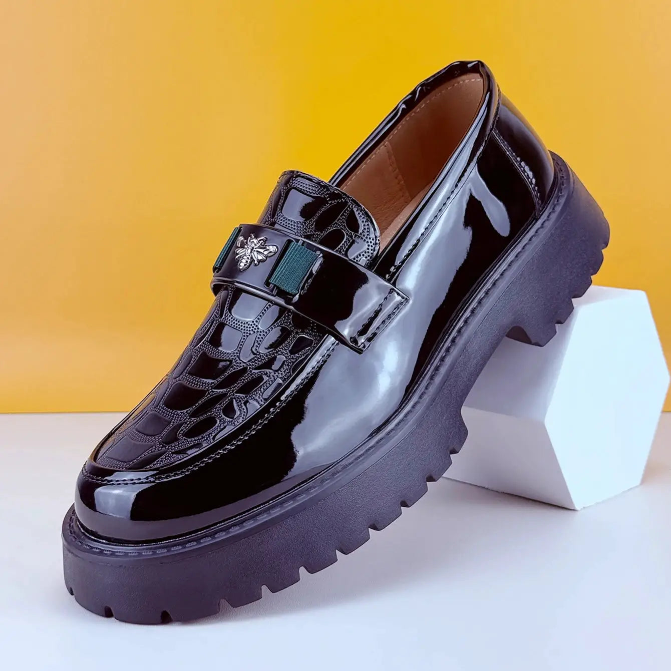 Black patent leather loafers with chunky sole, bee-embellished strap and embossed vamp