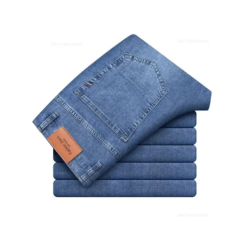 Six pairs of men's blue denim jeans stacked, leather patch label visible.
