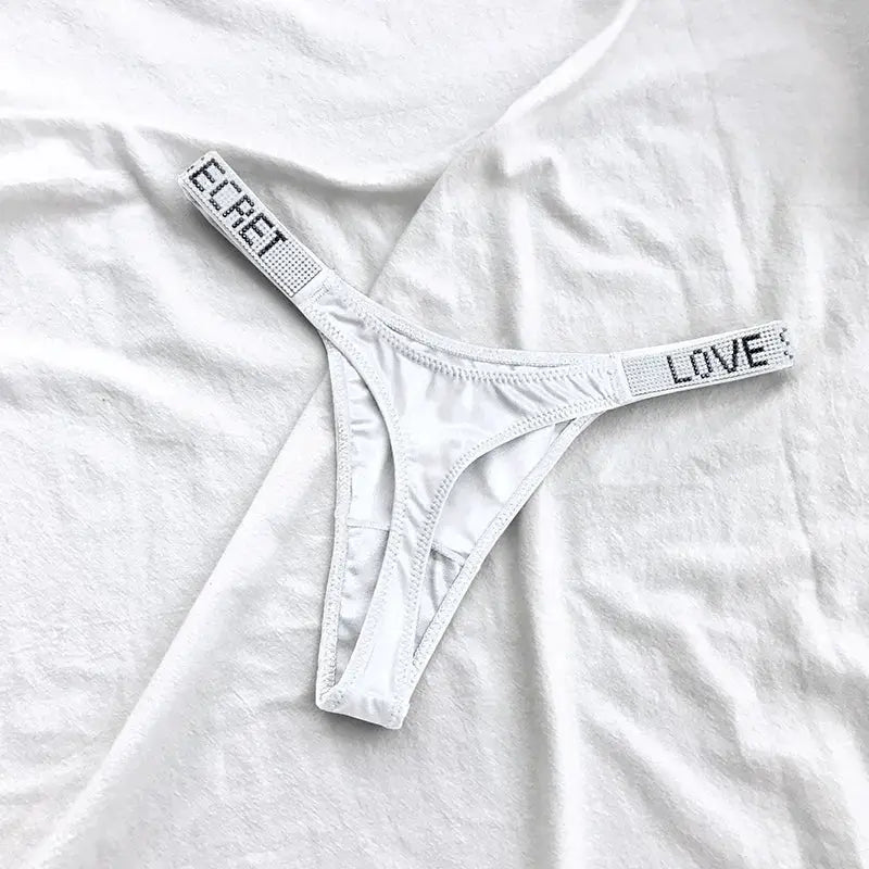 White low-waist thong with rhinestone LOVE lettering on waistband by Simples Market