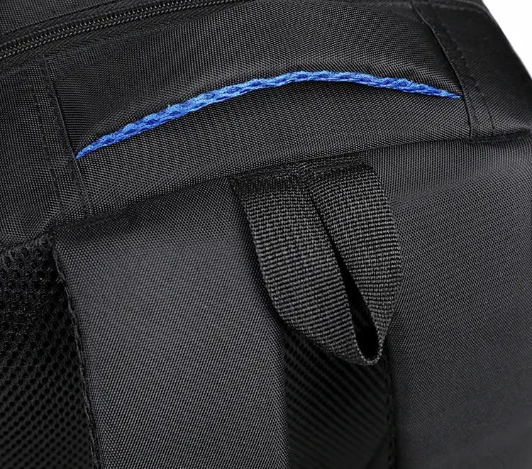 Backpack strap area in black fabric with blue accent stitching