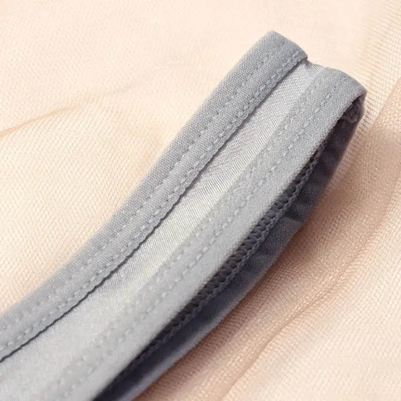 Low waist briefs with gray elastic waistband on beige sheer mesh fabric