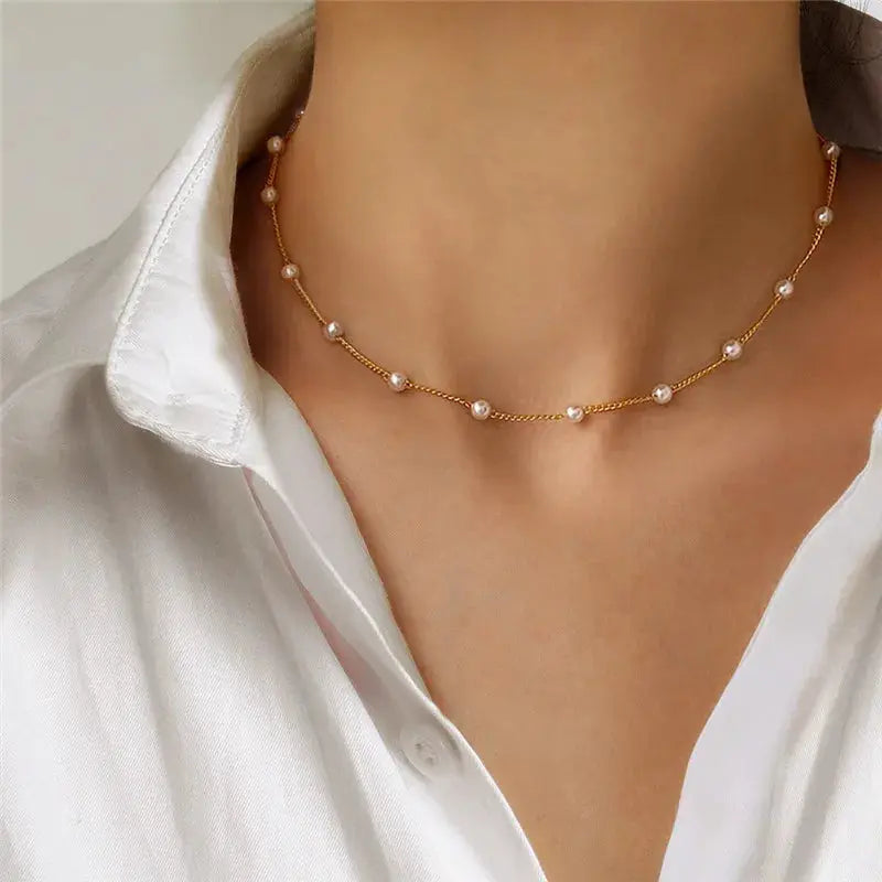 Gold-tone pearl bead choker necklace with small white pearls on a delicate chain.