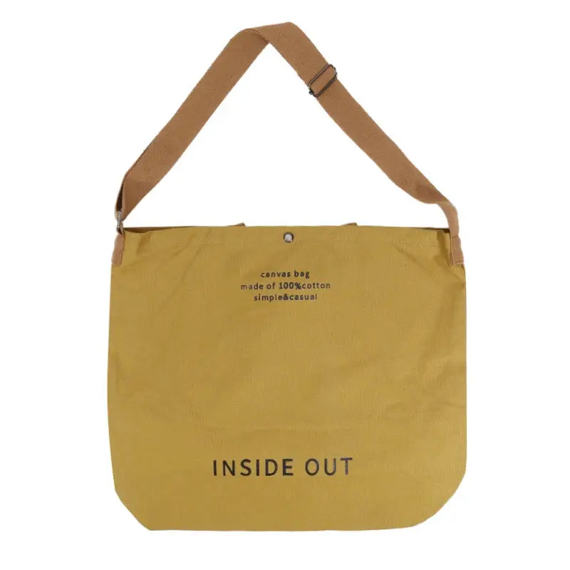 Canvas crossbody bag in mustard yellow with a thick brown strap, large capacity.