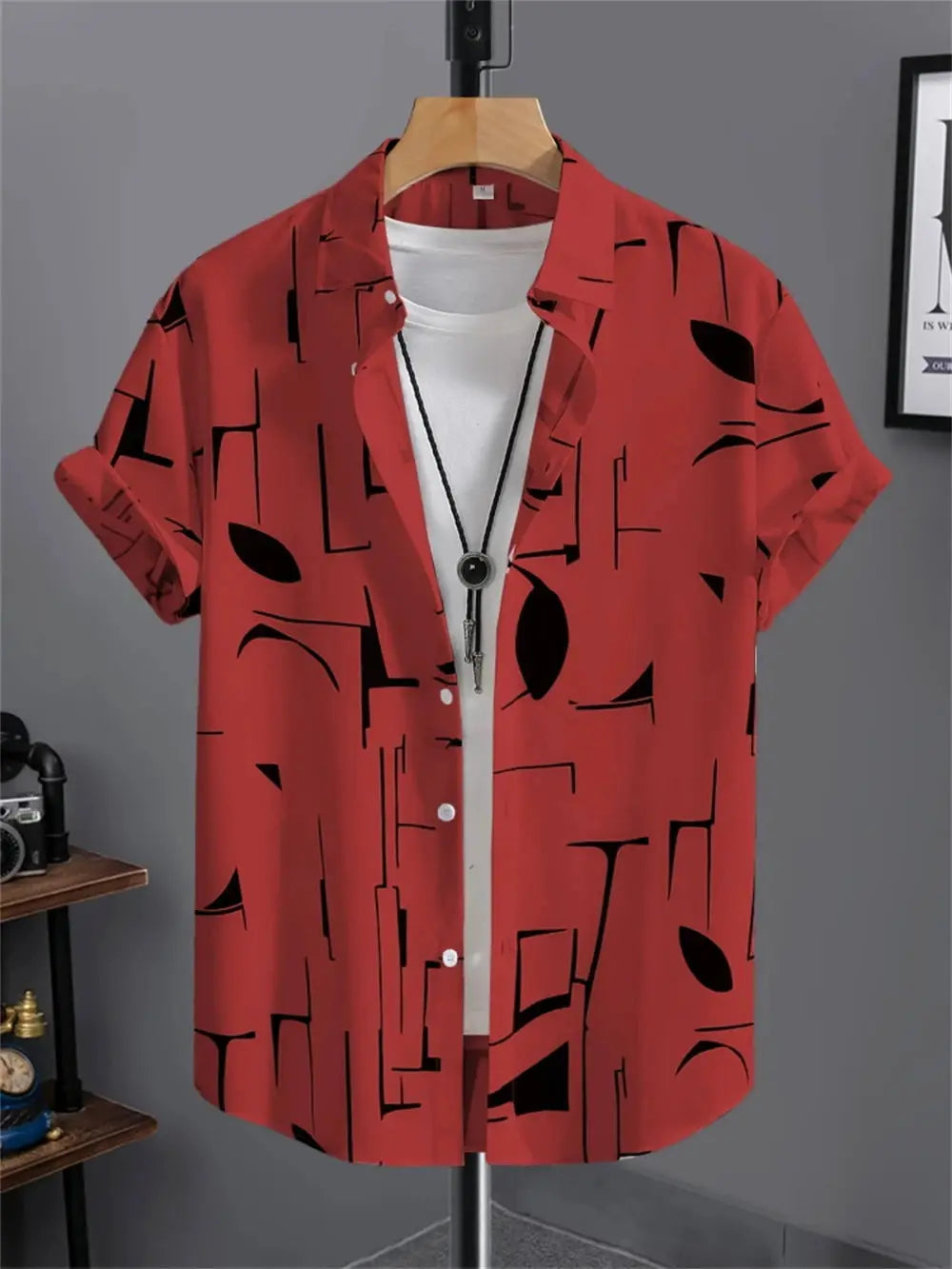Simple men's red short-sleeve shirt with black abstract geometric print on hanger